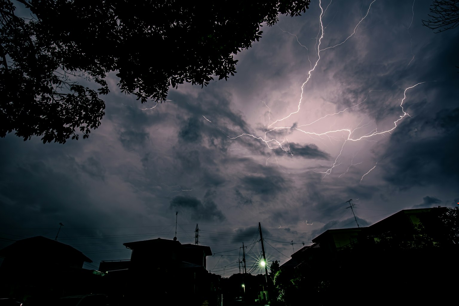Cielo oscuro con rayos y edificios en silueta