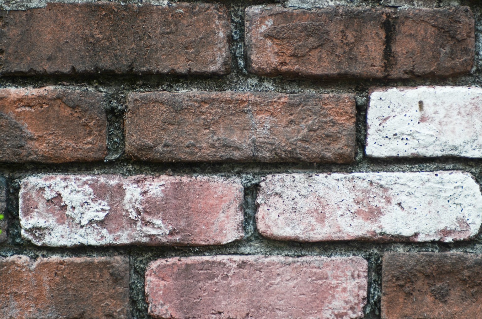 Texture d'un mur en briques avec des briques rougeâtre et blanches