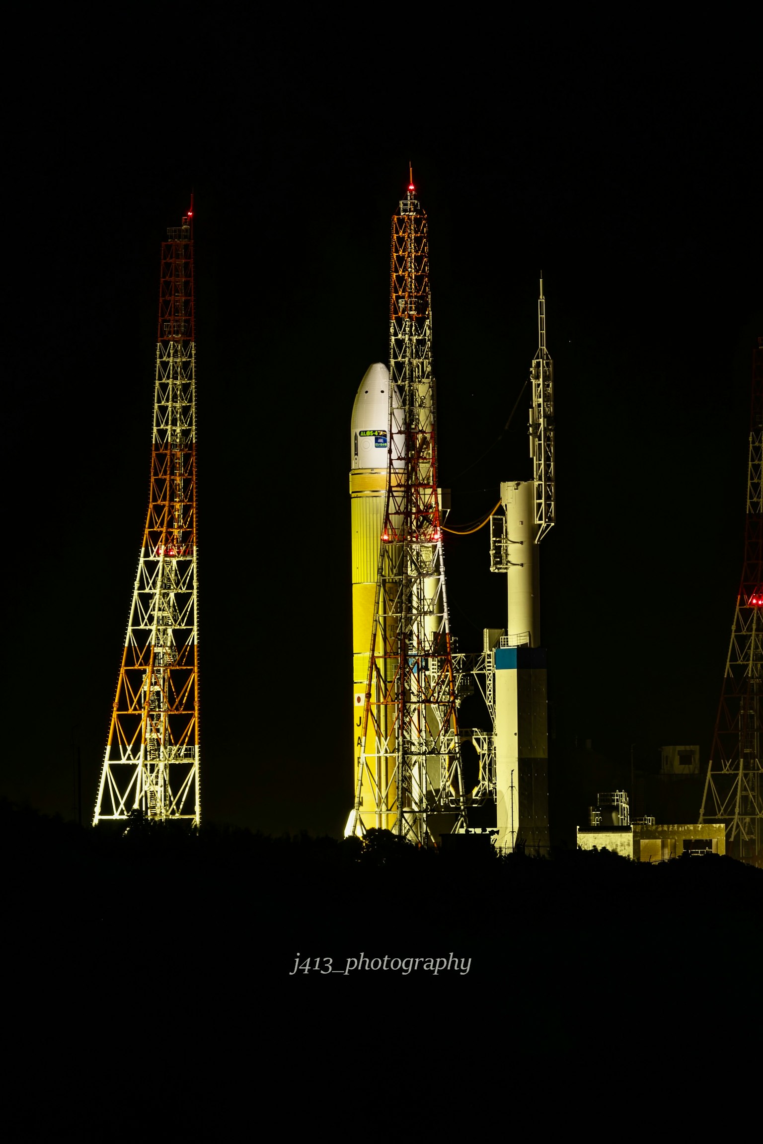 Rocket on the launch pad illuminated against the night sky