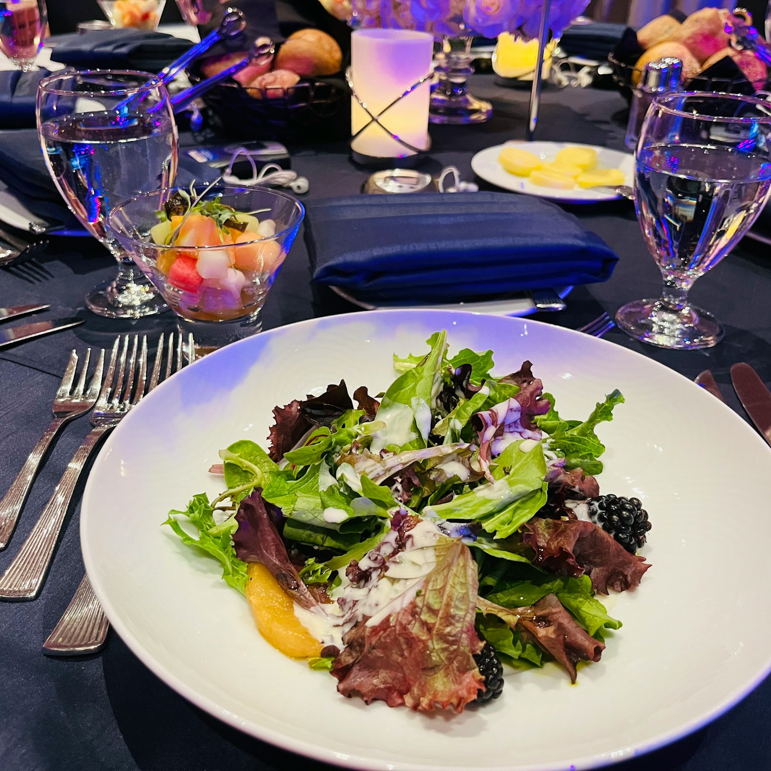 Un'insalata ben presentata su un piatto bianco con un'elegante apparecchiatura da tavola