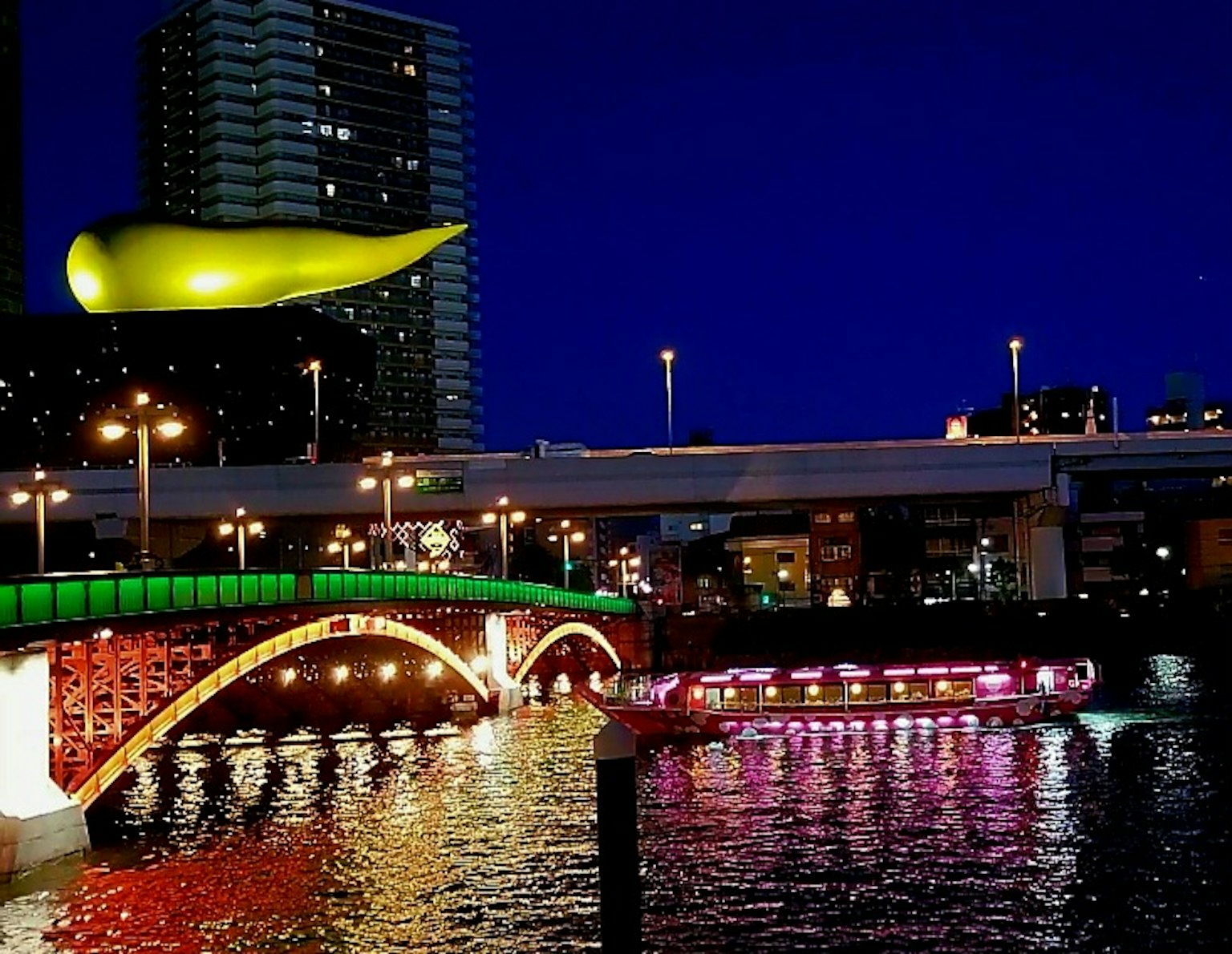 夜間河流的景色與色彩繽紛的橋樑和一個顯眼的黃色物體
