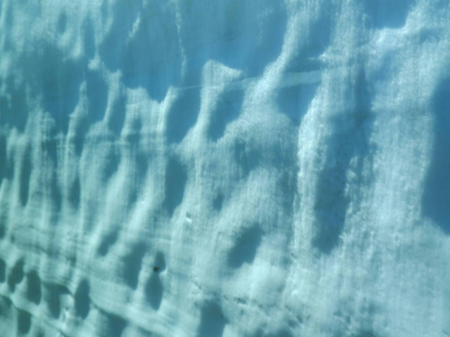 Image of water surface with beautiful blue hues and reflections of ripples
