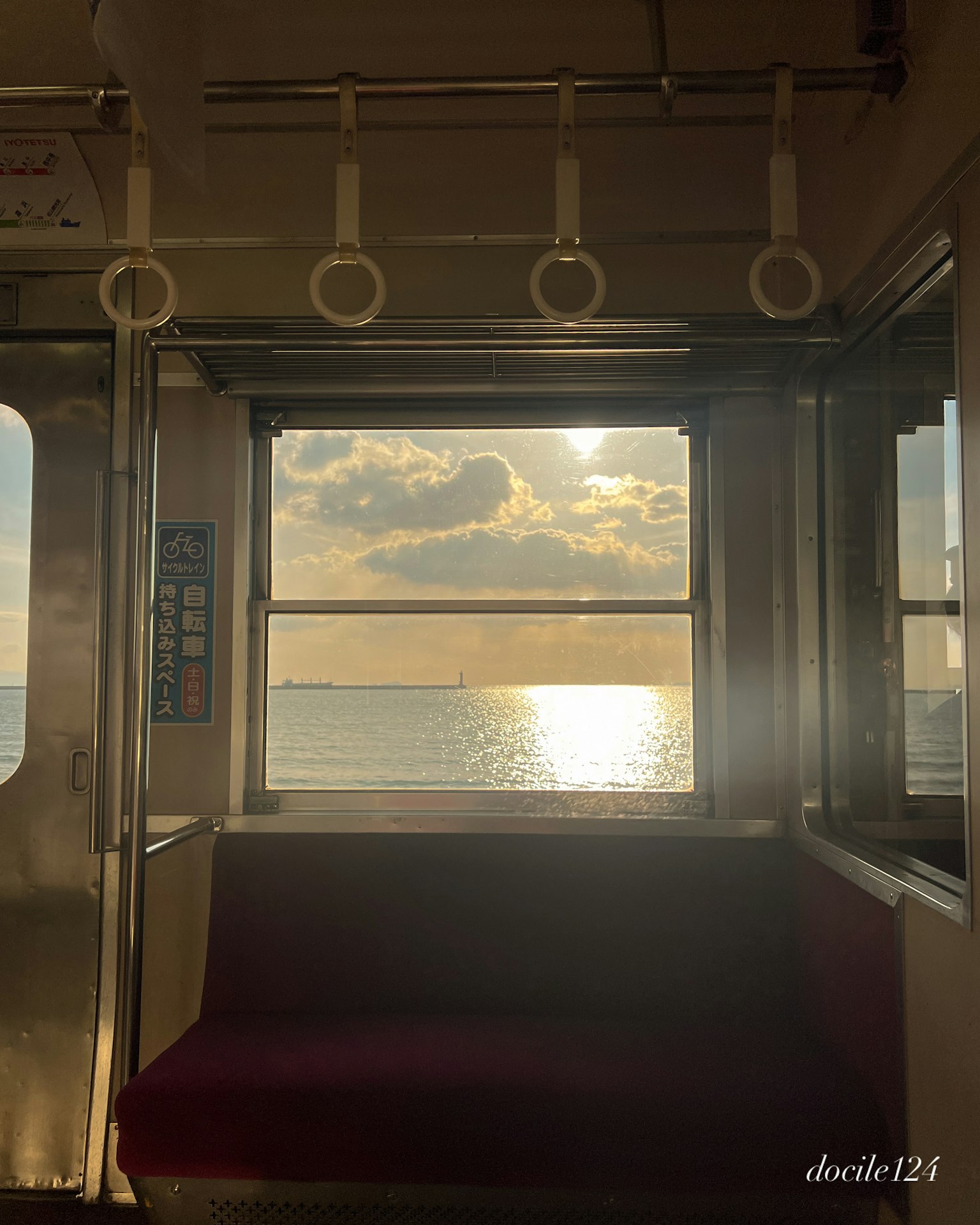 从火车车厢内看到的夕阳映在水面上