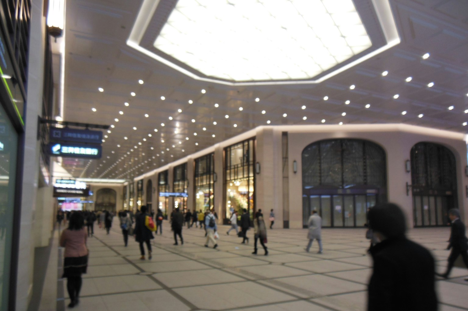Interior espacioso de una estación con iluminación brillante y muchas personas caminando