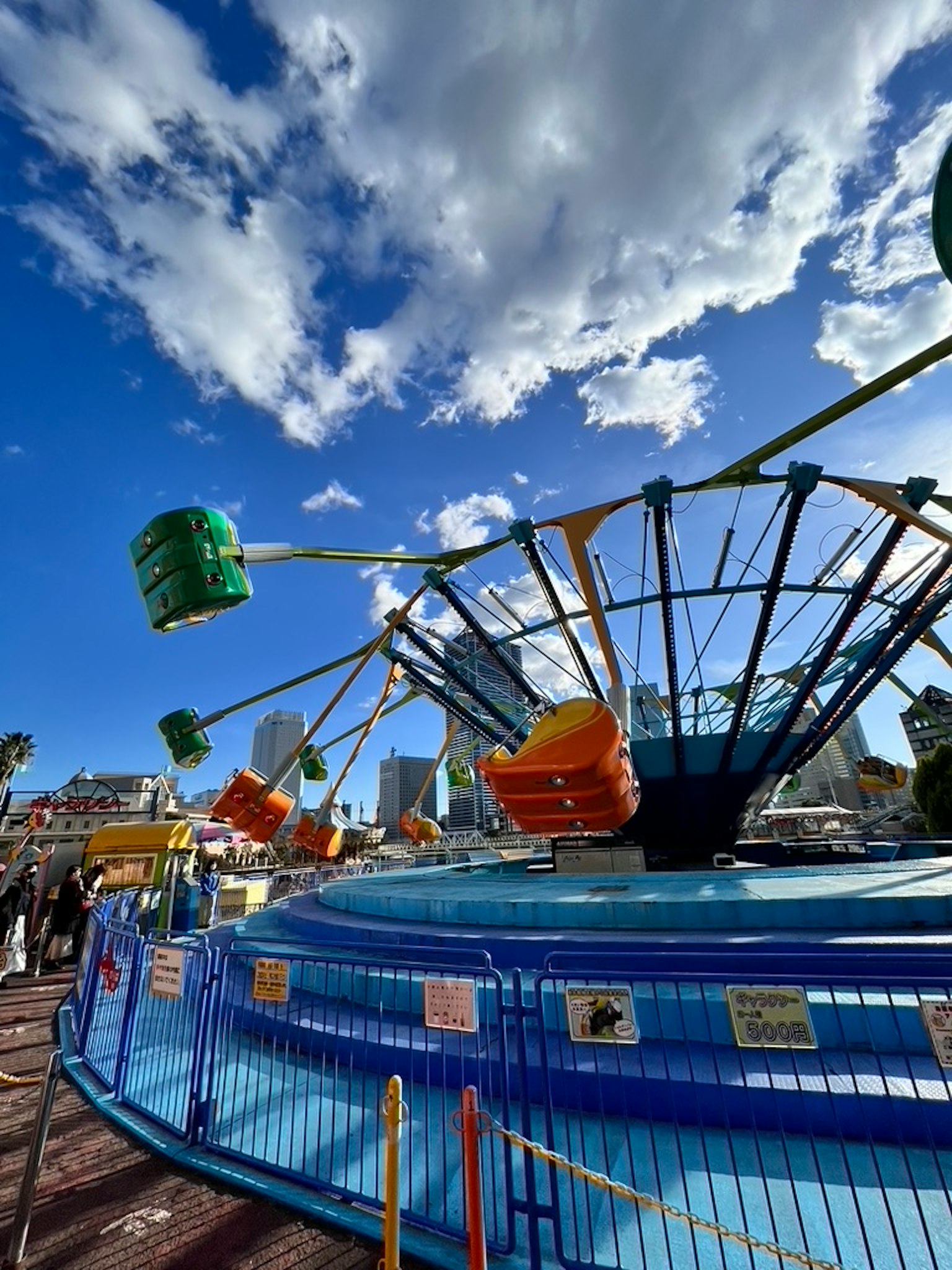 Giostra colorata di parco divertimenti con base blu e cielo nuvoloso