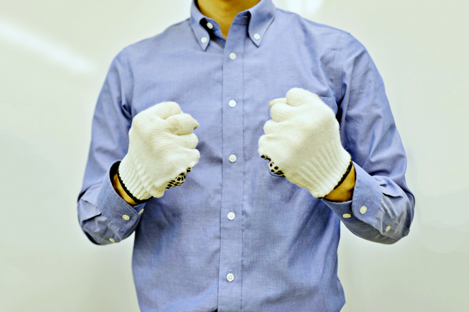 A man wearing white gloves is making fists