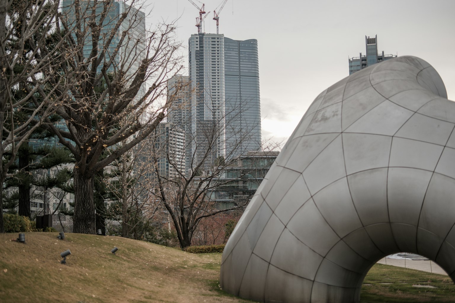 現代雕塑與高樓大廈在城市公園的景觀中