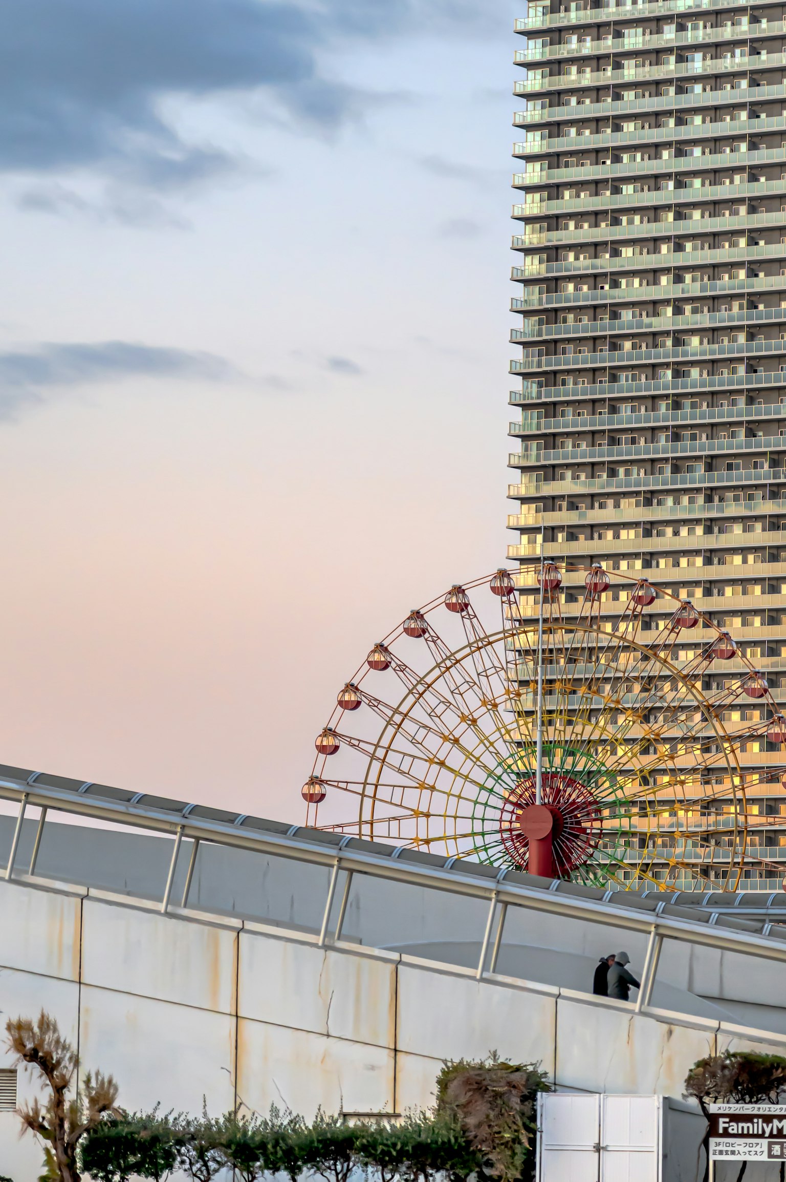 Ein Sonnenuntergangsbild mit einem Wolkenkratzer und einem Riesenrad im Hintergrund