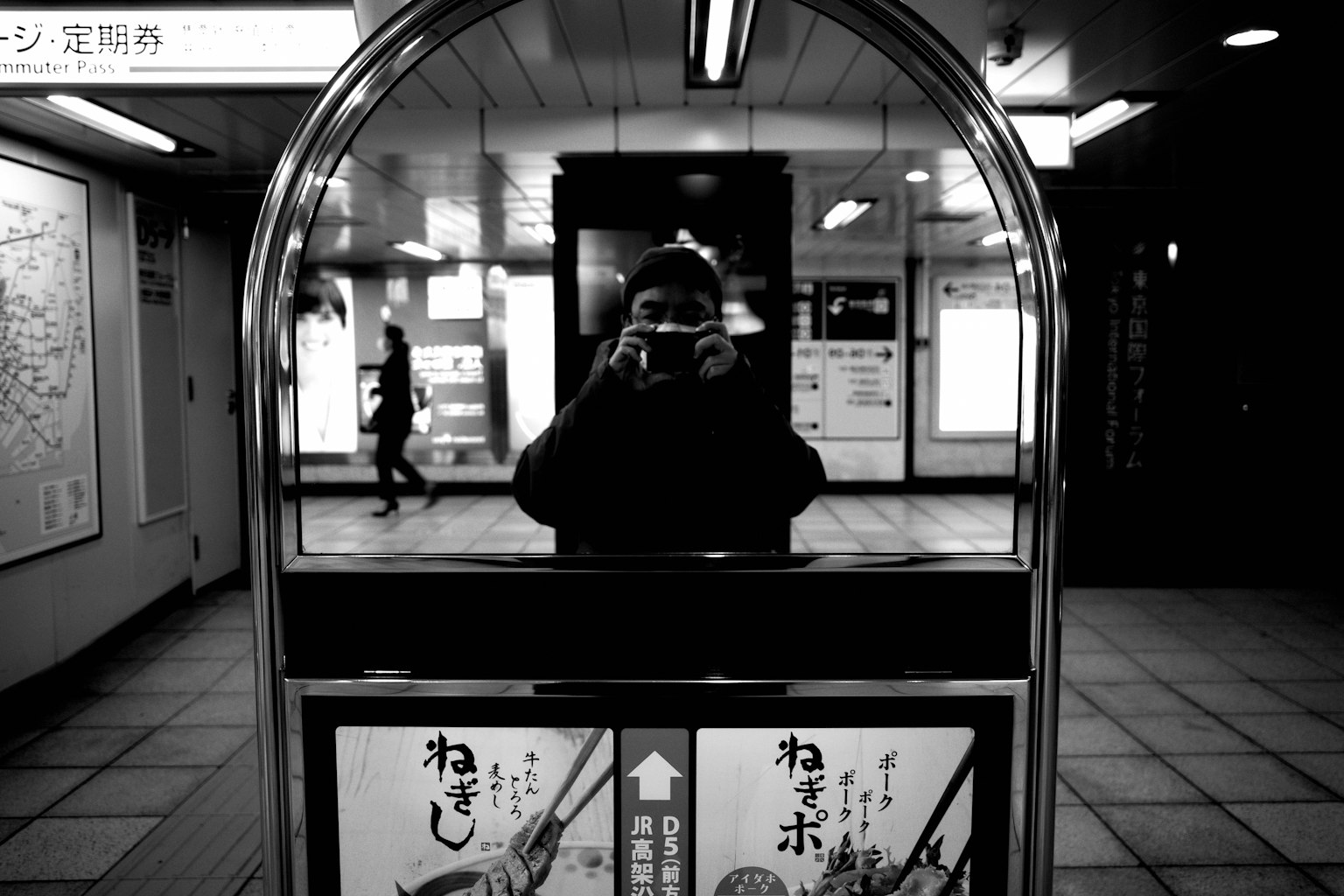 Foto en blanco y negro de una persona reflejada en un espejo de metro