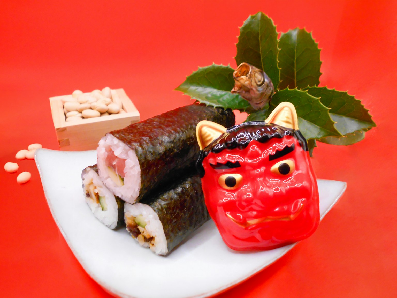 Sushi-Rollen mit roter Dämonen-Dekoration auf rotem Hintergrund