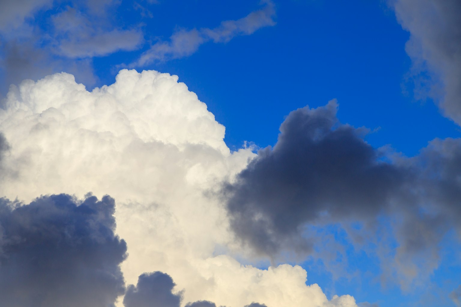 Contrast of white and dark clouds against a blue sky
