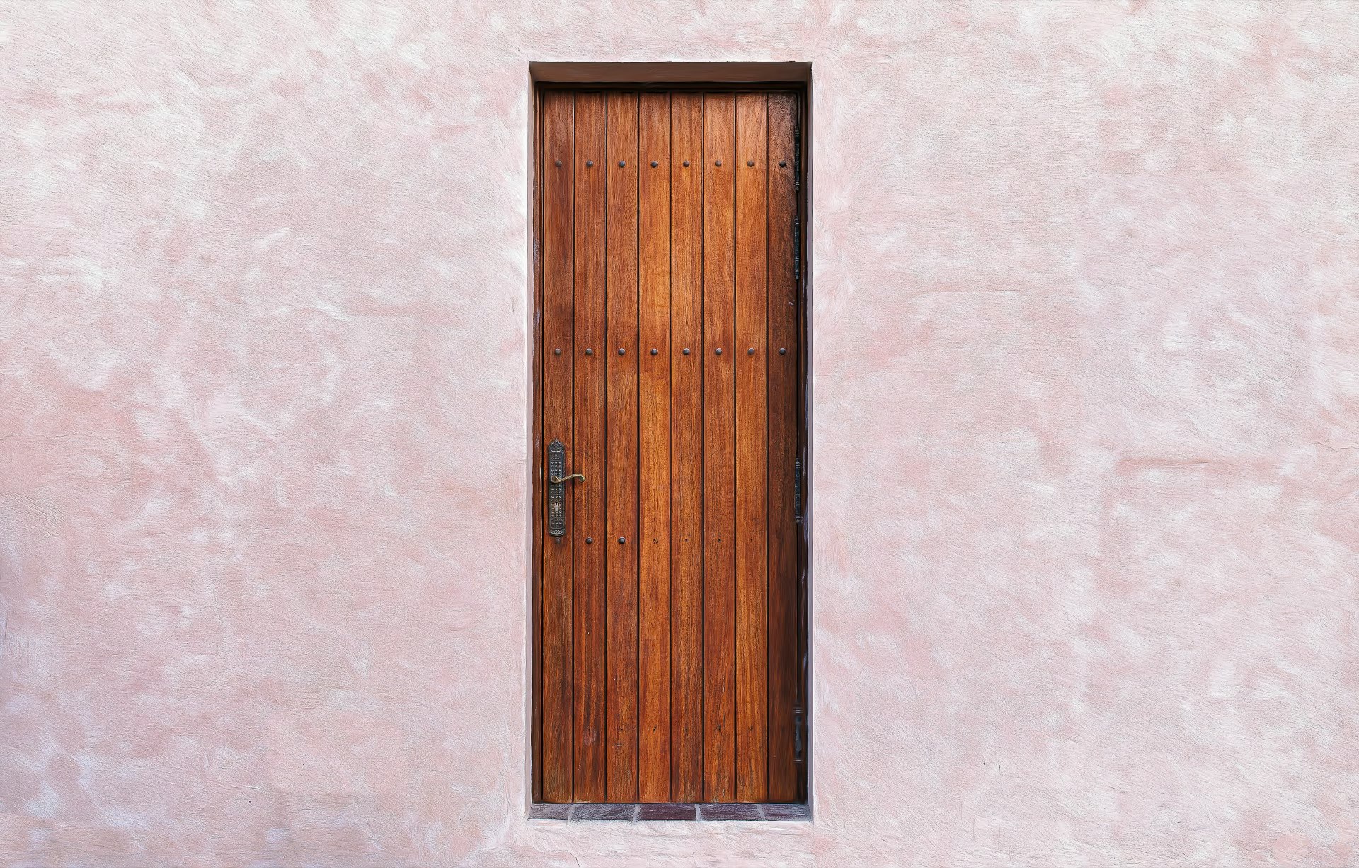 porte d’entrée en bois sur un mur rose