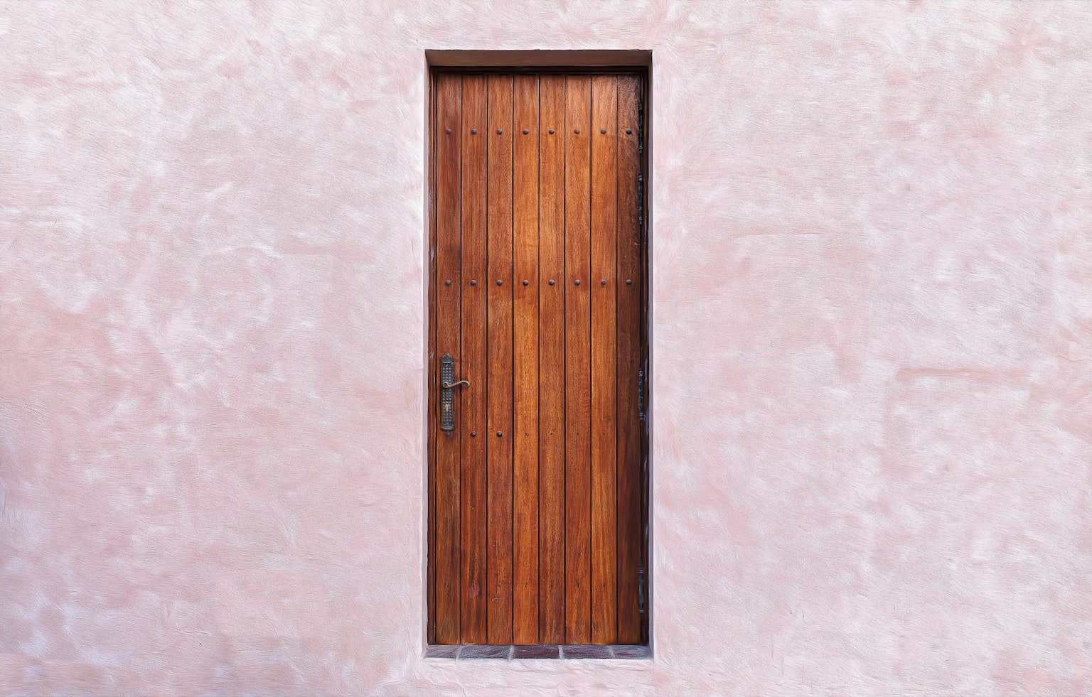 Una puerta de madera montada en una pared rosa que muestra un diseño simple y hermoso