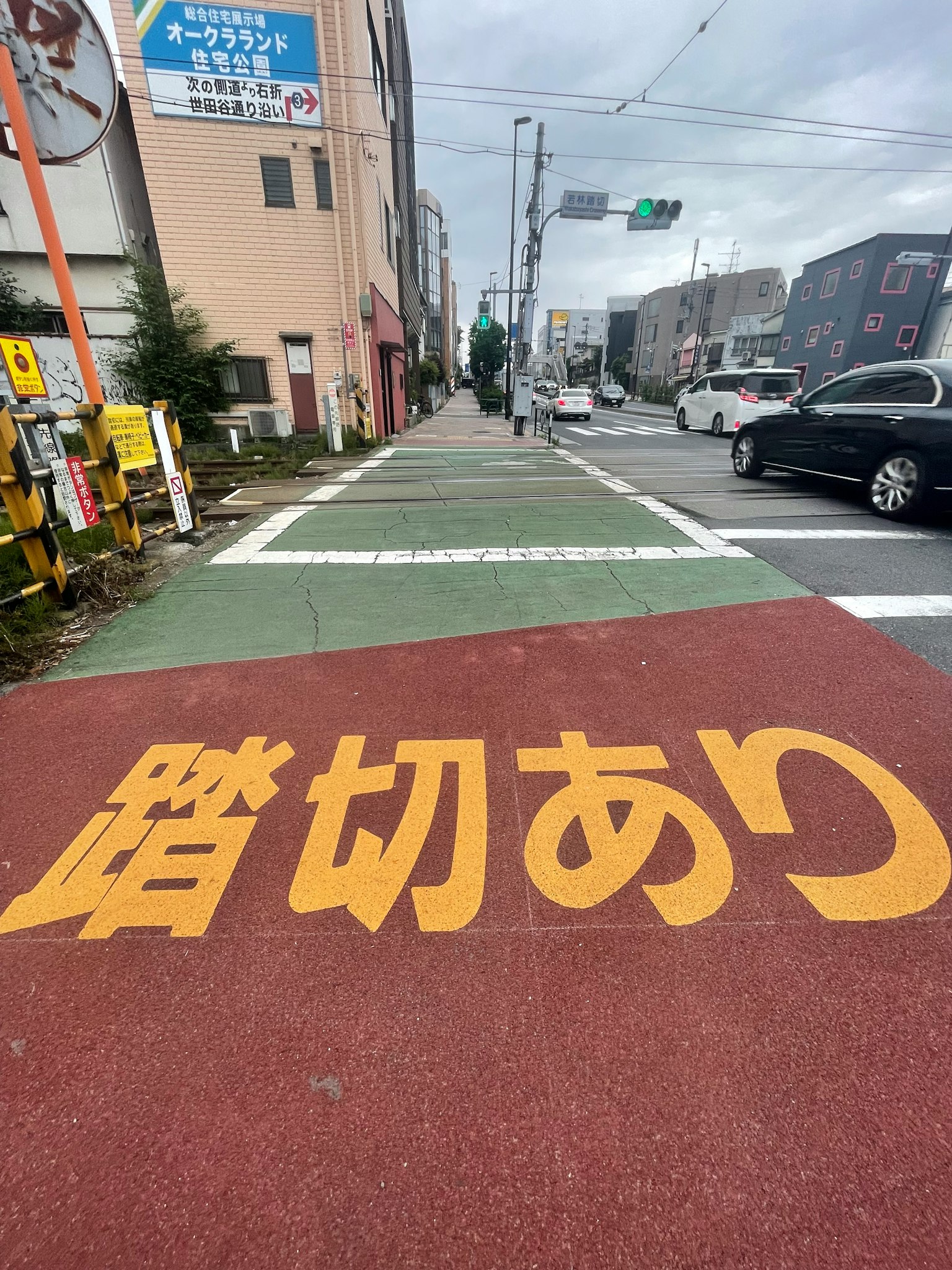人行道上有红色铺装和黄色文字，写着'踏切あり'