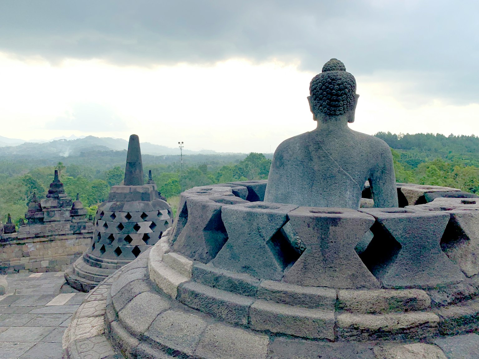 Vue du temple de Borobudur avec une statue de Bouddha assise de dos