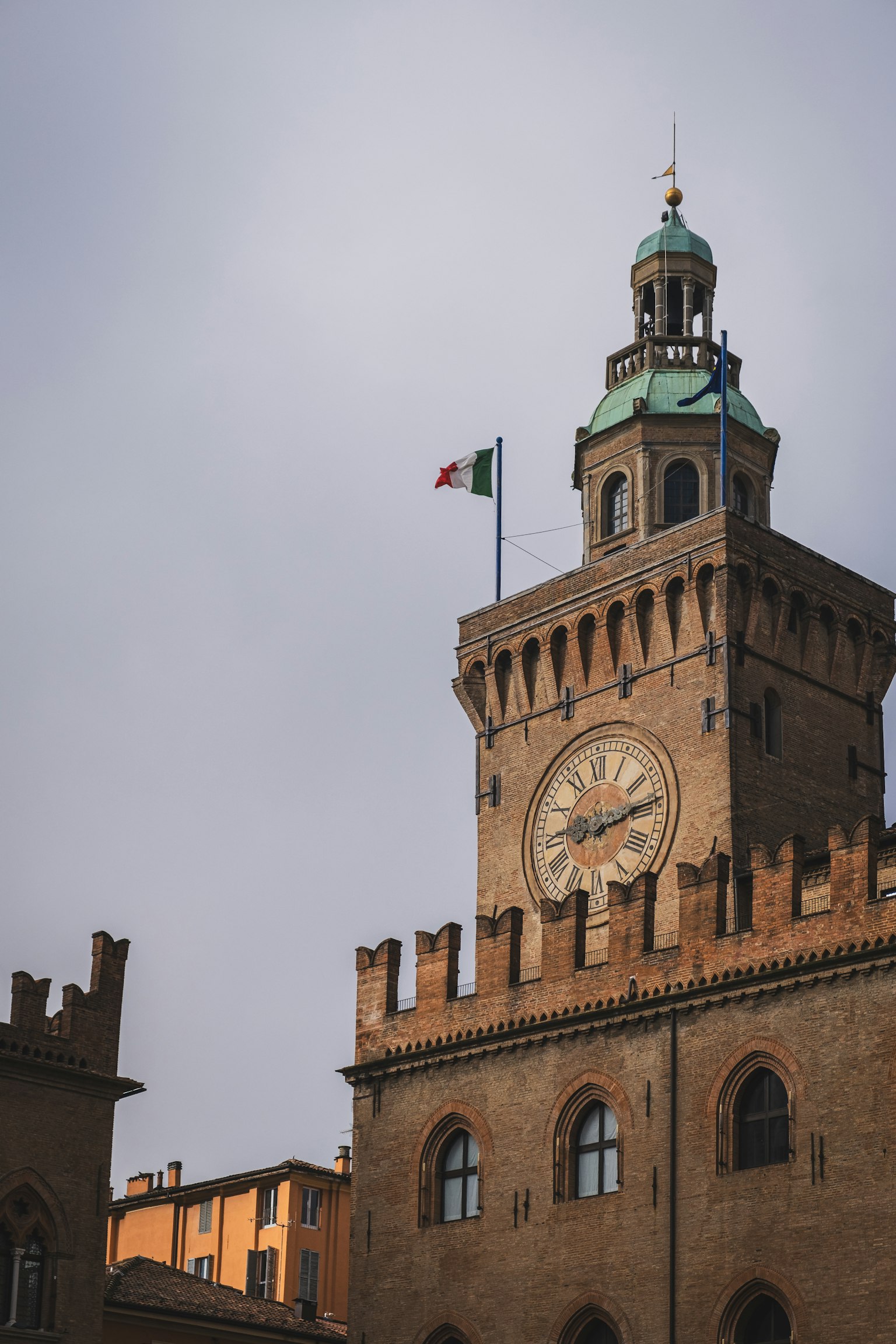 Tháp đồng hồ của tòa thị chính Bologna với cờ Italy