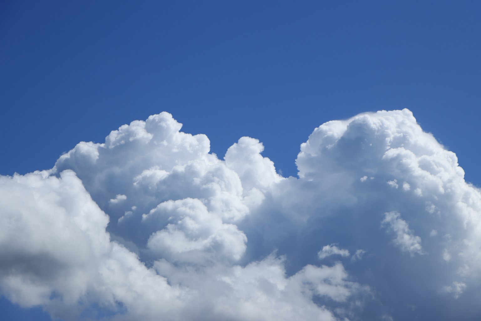 Fluffy white clouds against a clear blue sky
