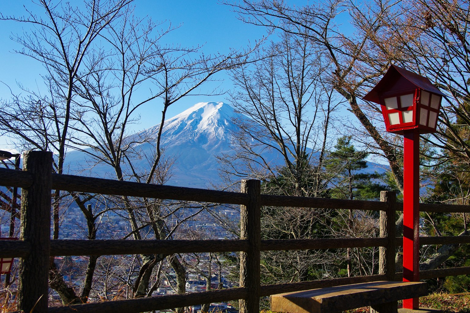 Pemandangan Gunung Fuji dengan lentera merah dan pagar kayu di latar depan