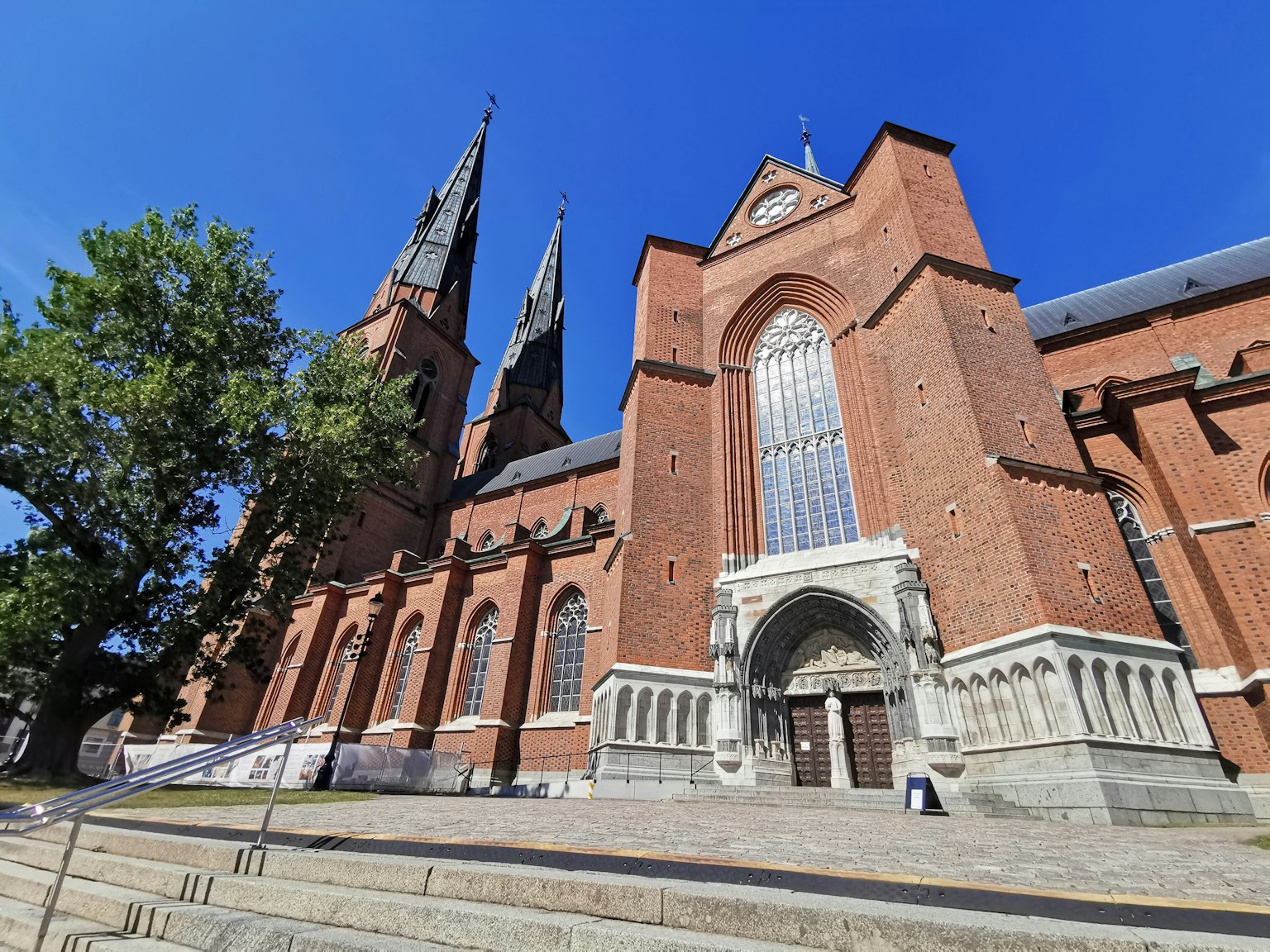 Exterior view of a brick church with tall spires and large windows
