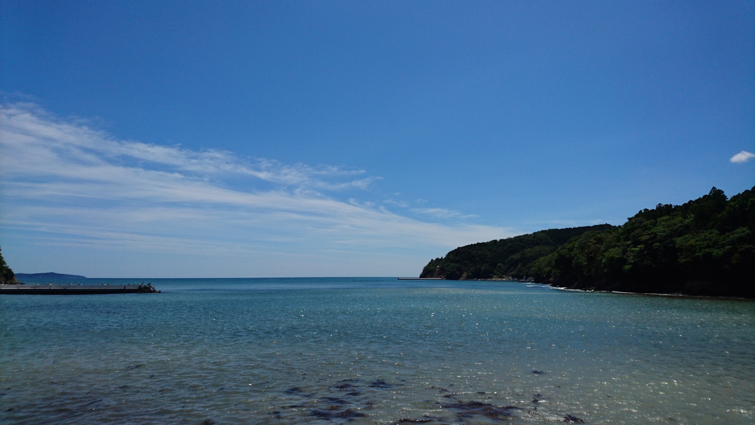 Vue panoramique de la mer et du ciel bleus avec des collines vertes en arrière-plan