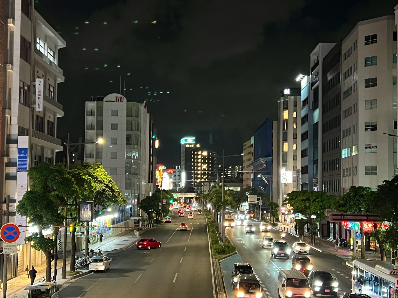 ทิวทัศน์ยามค่ำคืนของถนนในเมืองที่มีอาคารและรถยนต์