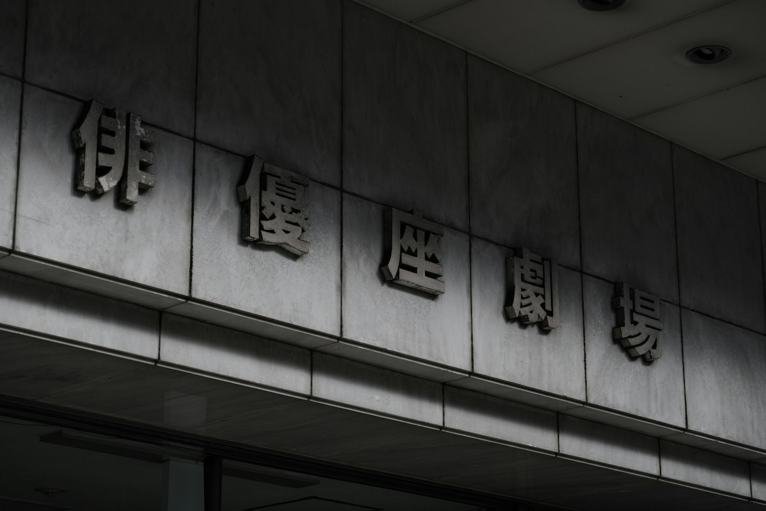 Metallisches Schild mit Zeichen an einer Gebäudewand