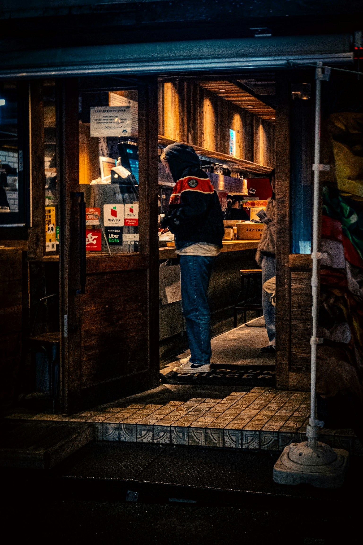 難波の夜の路地で灯る店先と人影