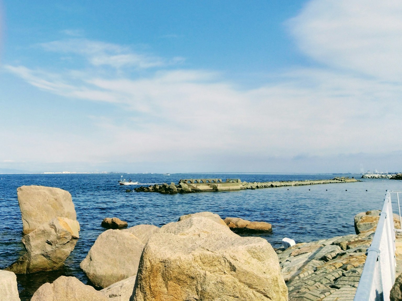 蓝色海洋和天空的风景 大岩石和码头可见