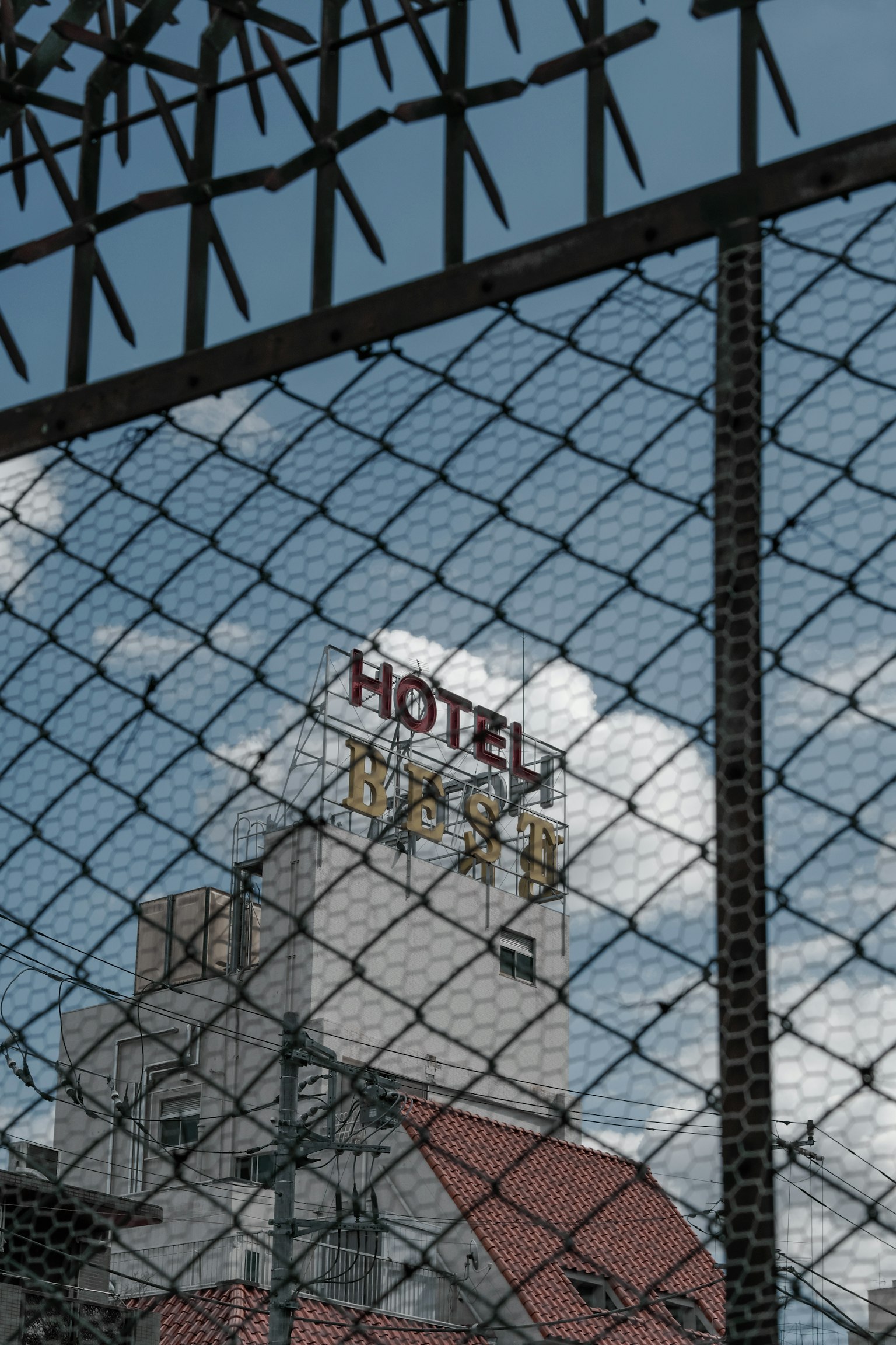 Cartel de hotel visible a través de una cerca con cielo azul