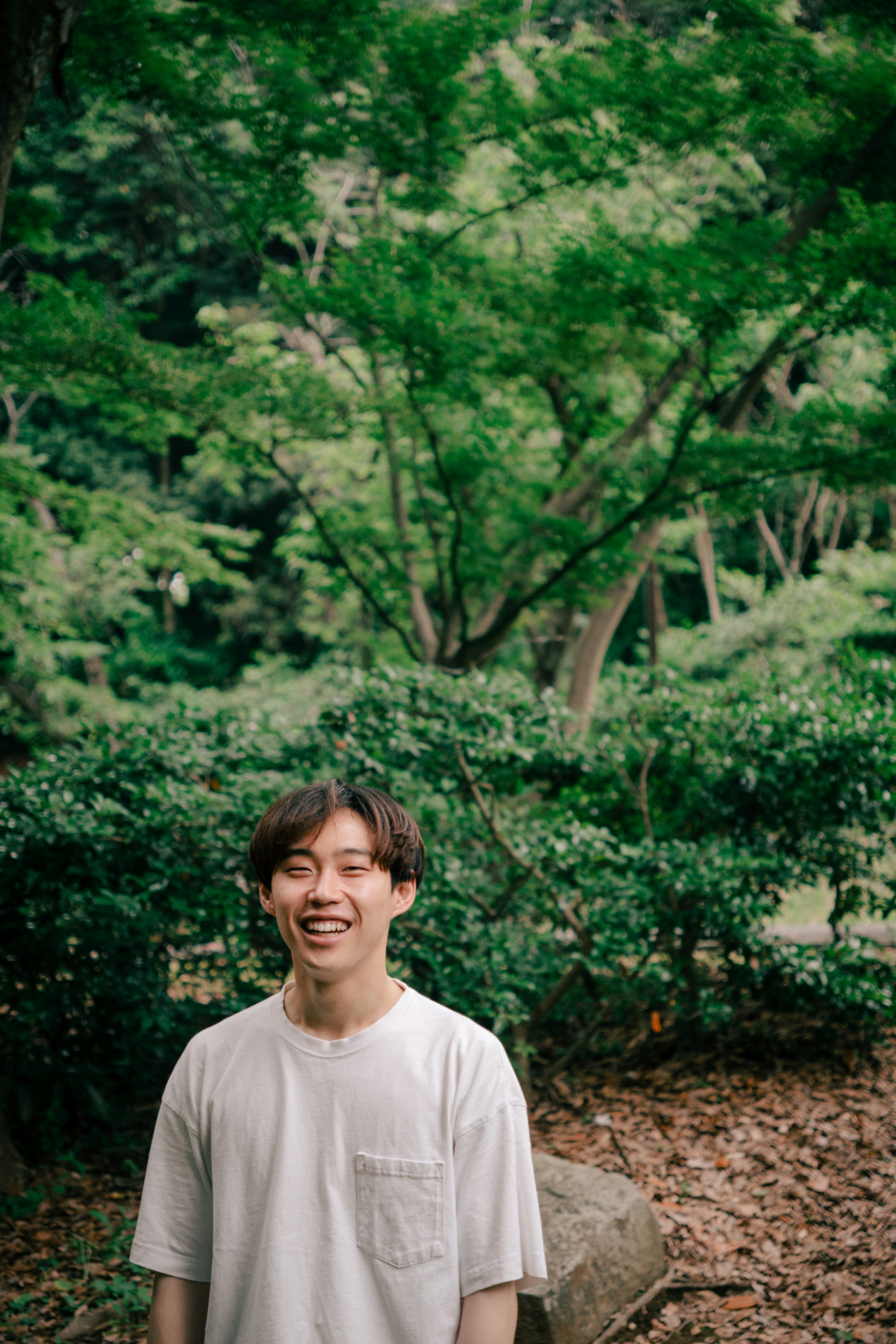 緑の木々の中で微笑む男性