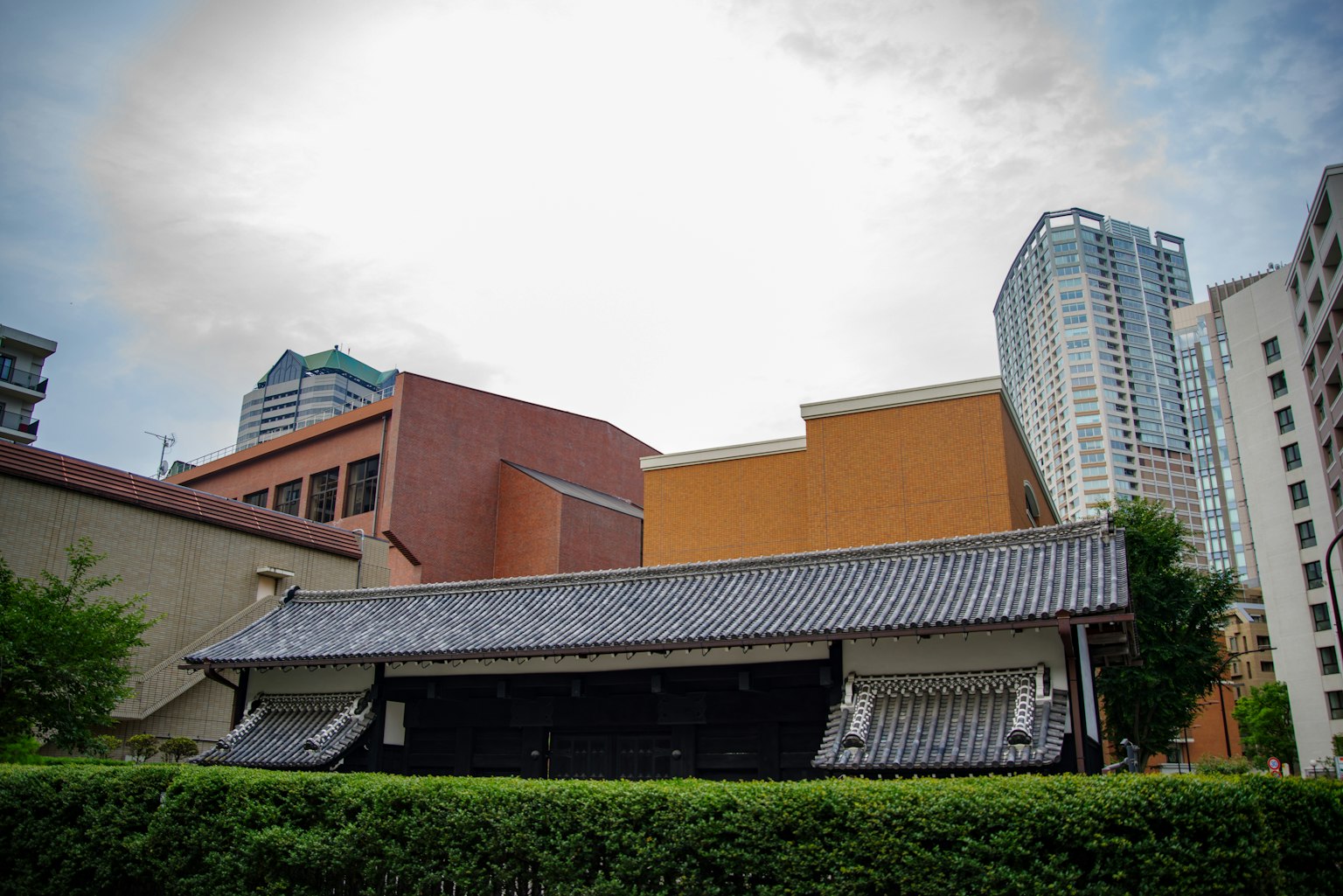 Un contraste entre des gratte-ciels modernes et un bâtiment japonais traditionnel