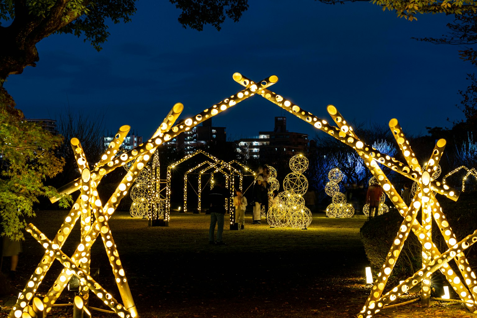 Arco illuminato di notte con decorazioni di pupazzi di neve in un parco