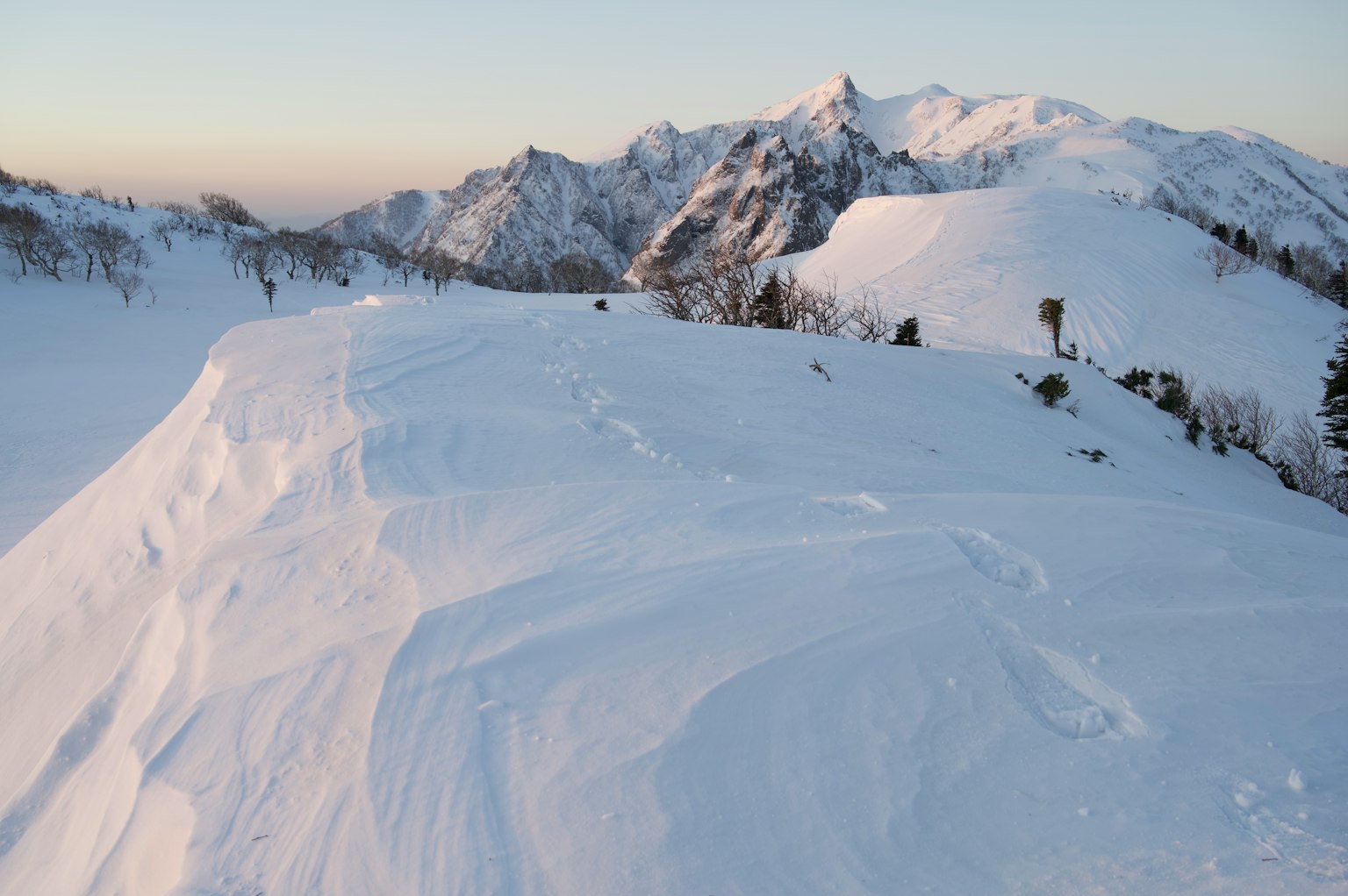 Paesaggio montano coperto di neve con colline di neve lisce