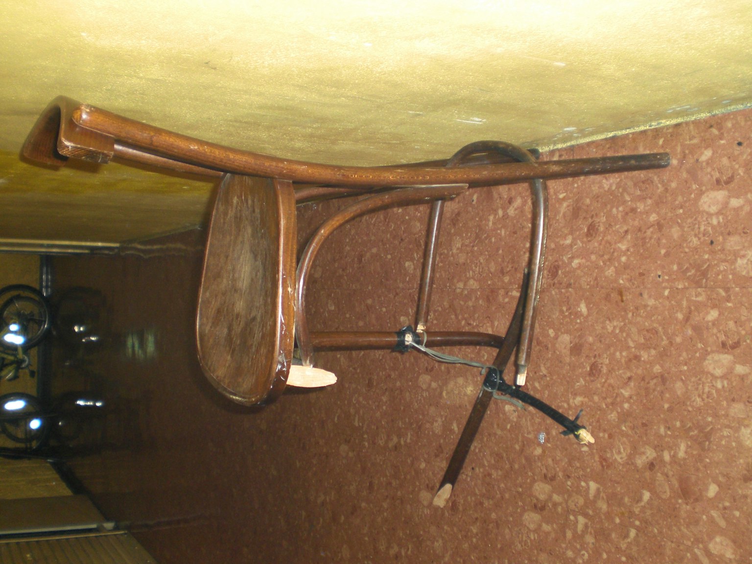 An old wooden chair leaning against a wall