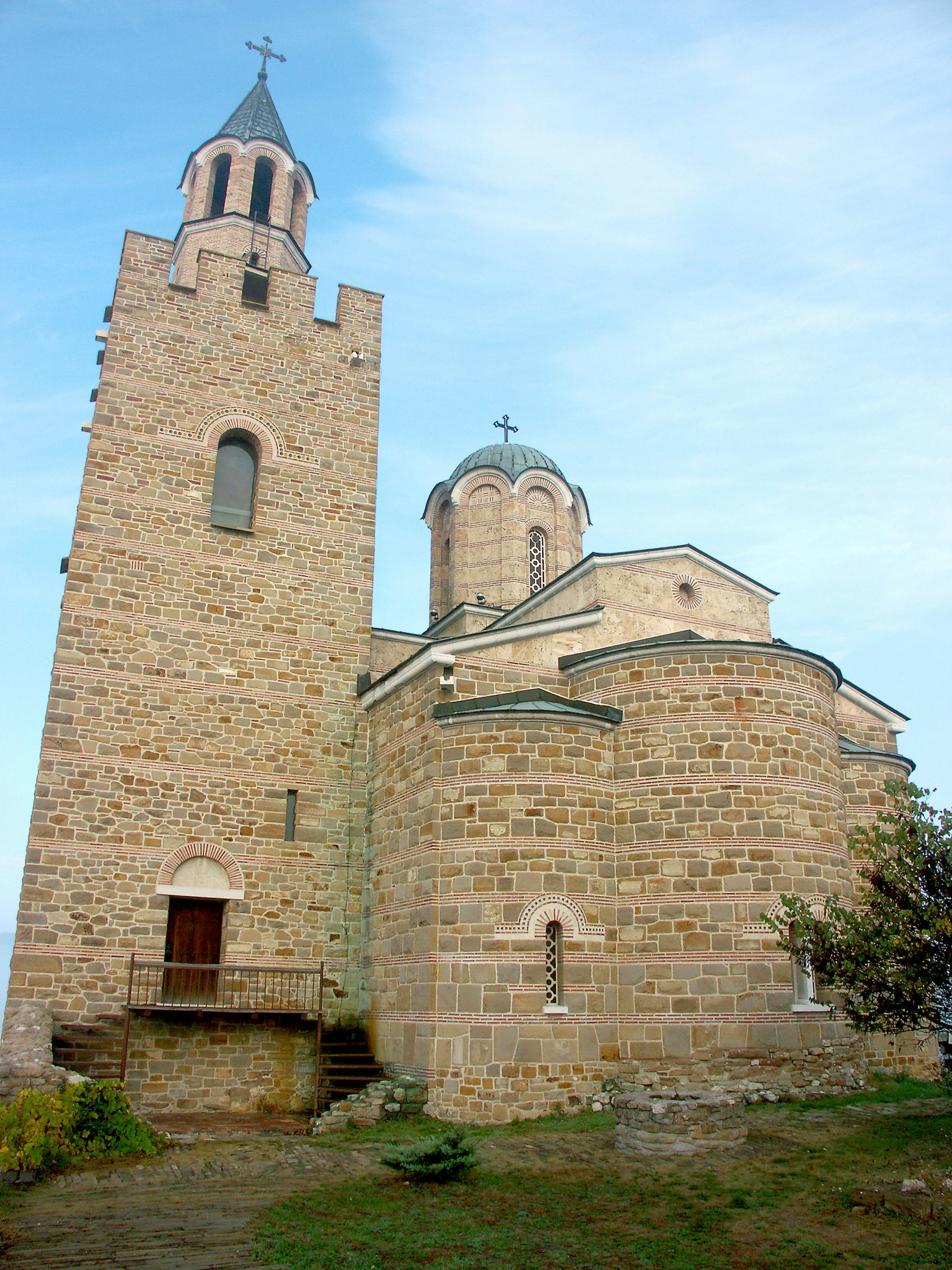 Iglesia de piedra con torre y estructuras en cúpula
