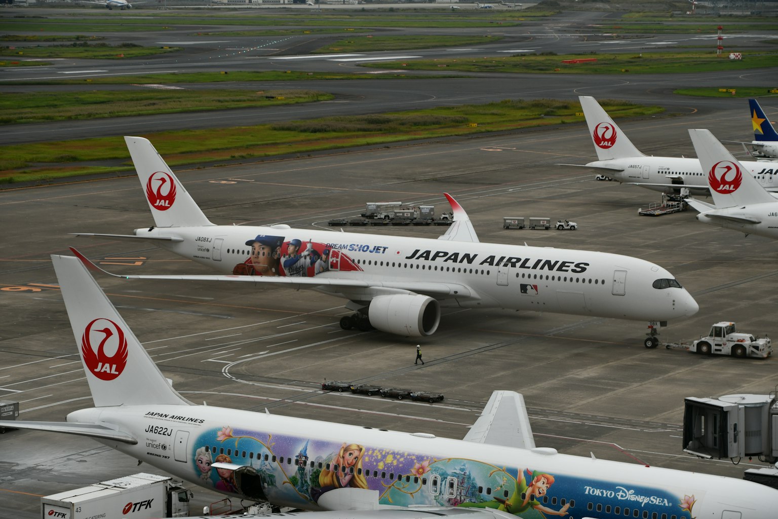 日本航空飞机停在停机坪上，带有多彩设计