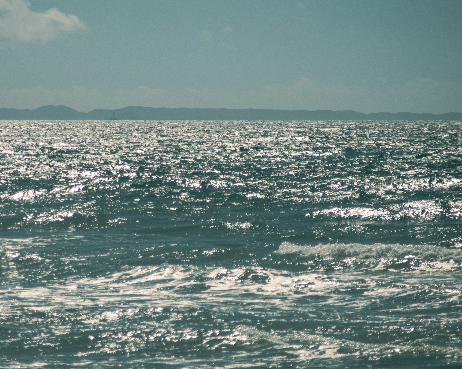 Vista del mar tranquilo con olas brillantes e islas distantes