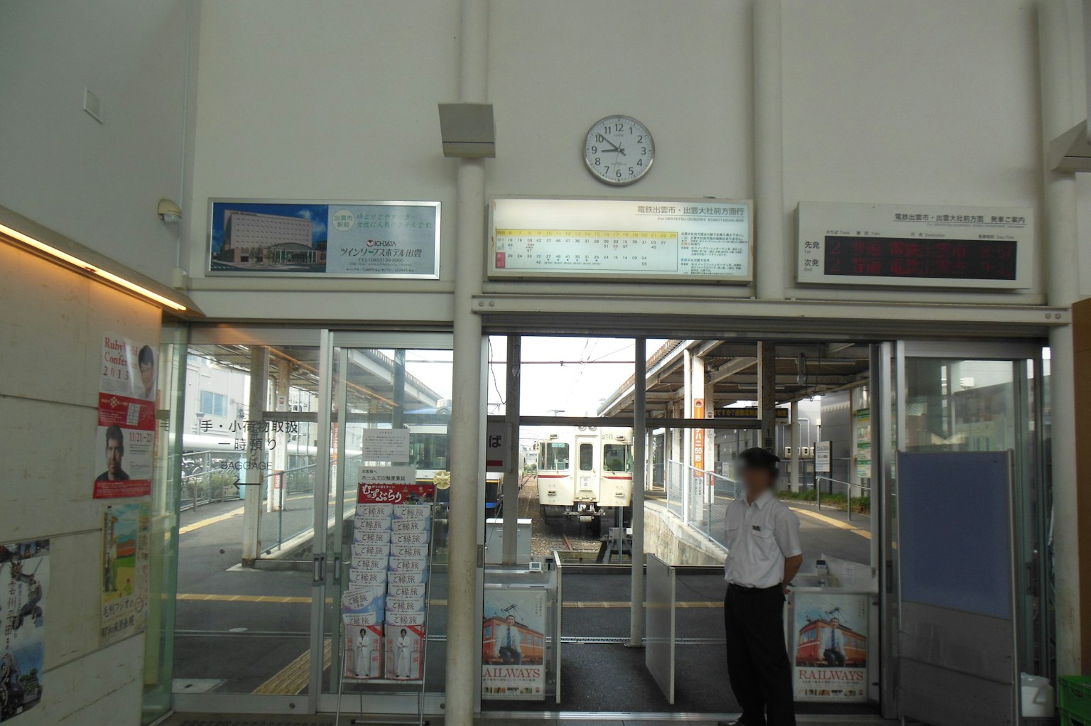 Train station entrance with clock and visible train