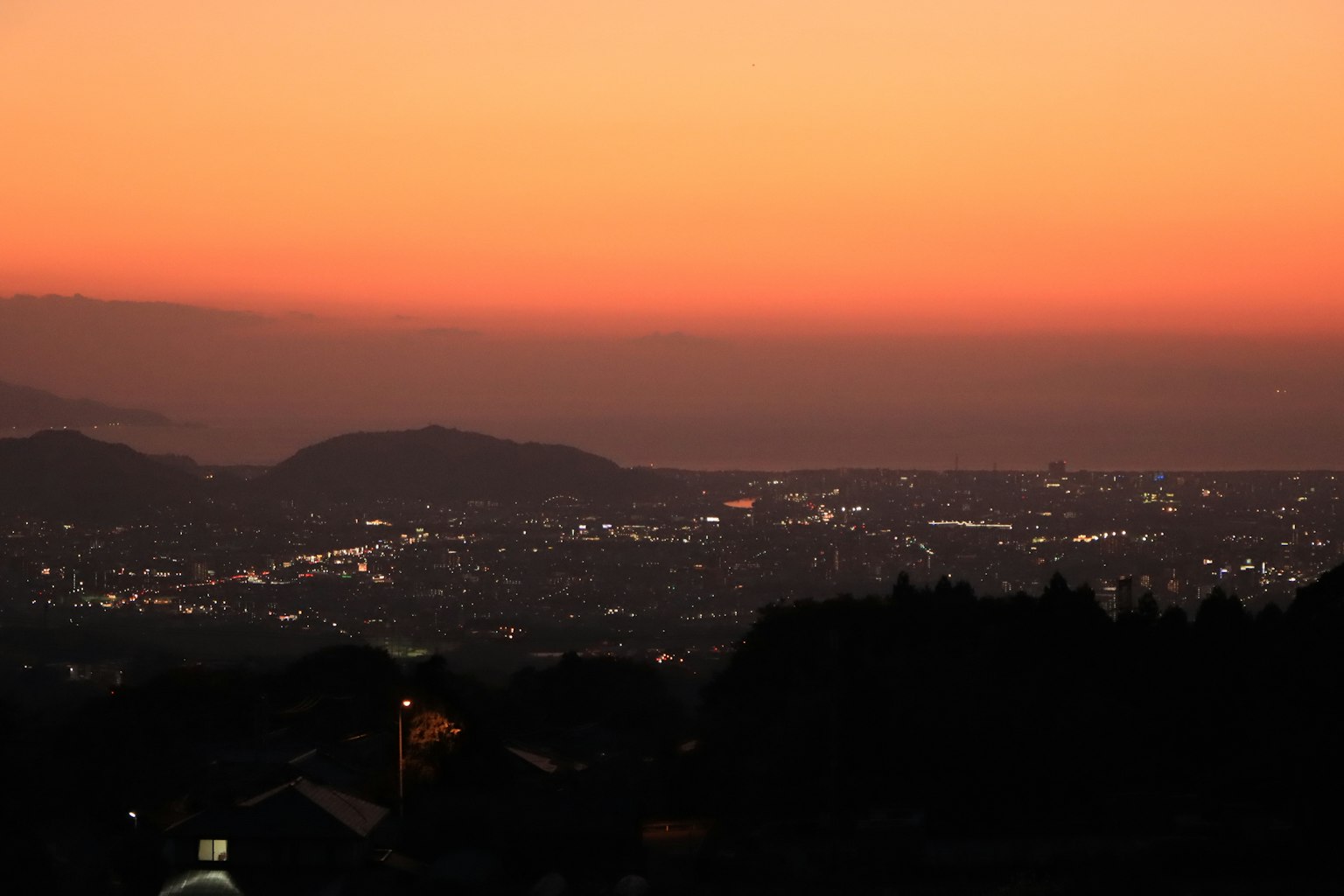 夕焼けの空と街の明かりが広がる風景