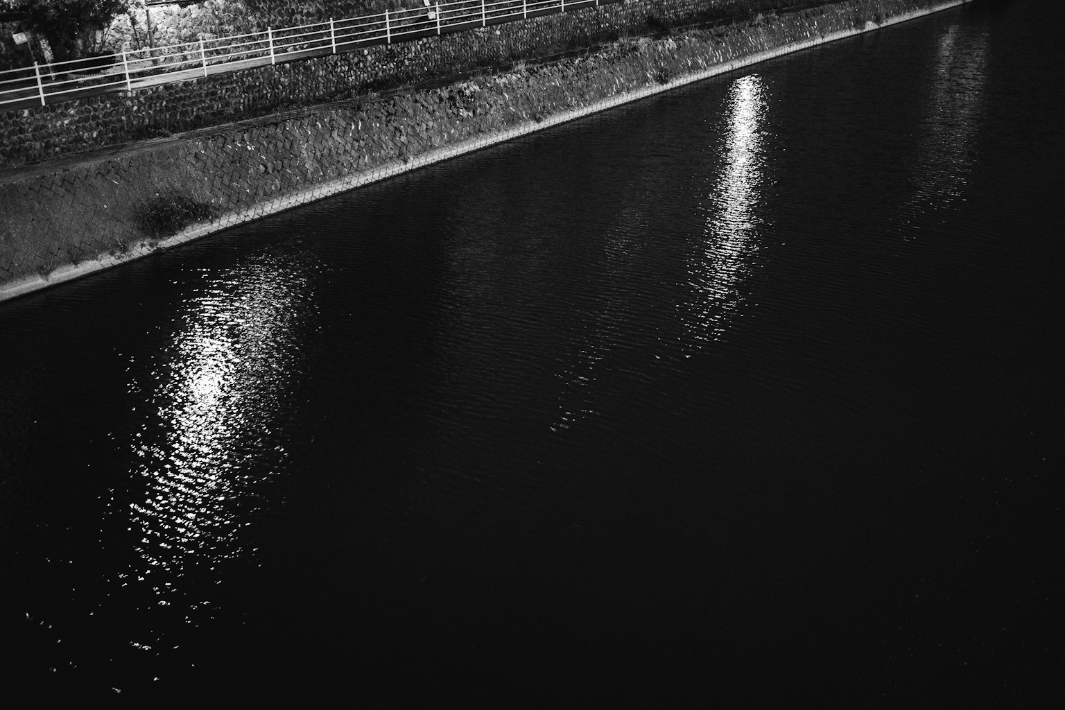 夜晚黑暗河面上燈光的倒影