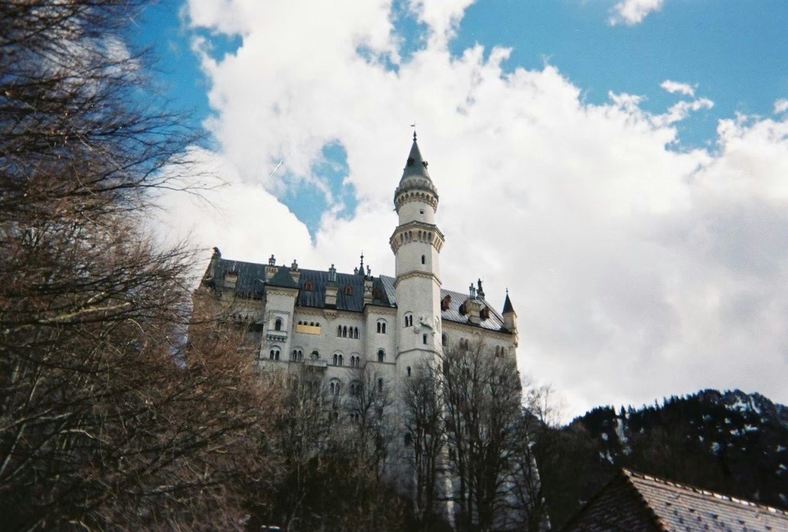 Menara megah Kastil Neuschwanstein di latar belakang pegunungan yang indah