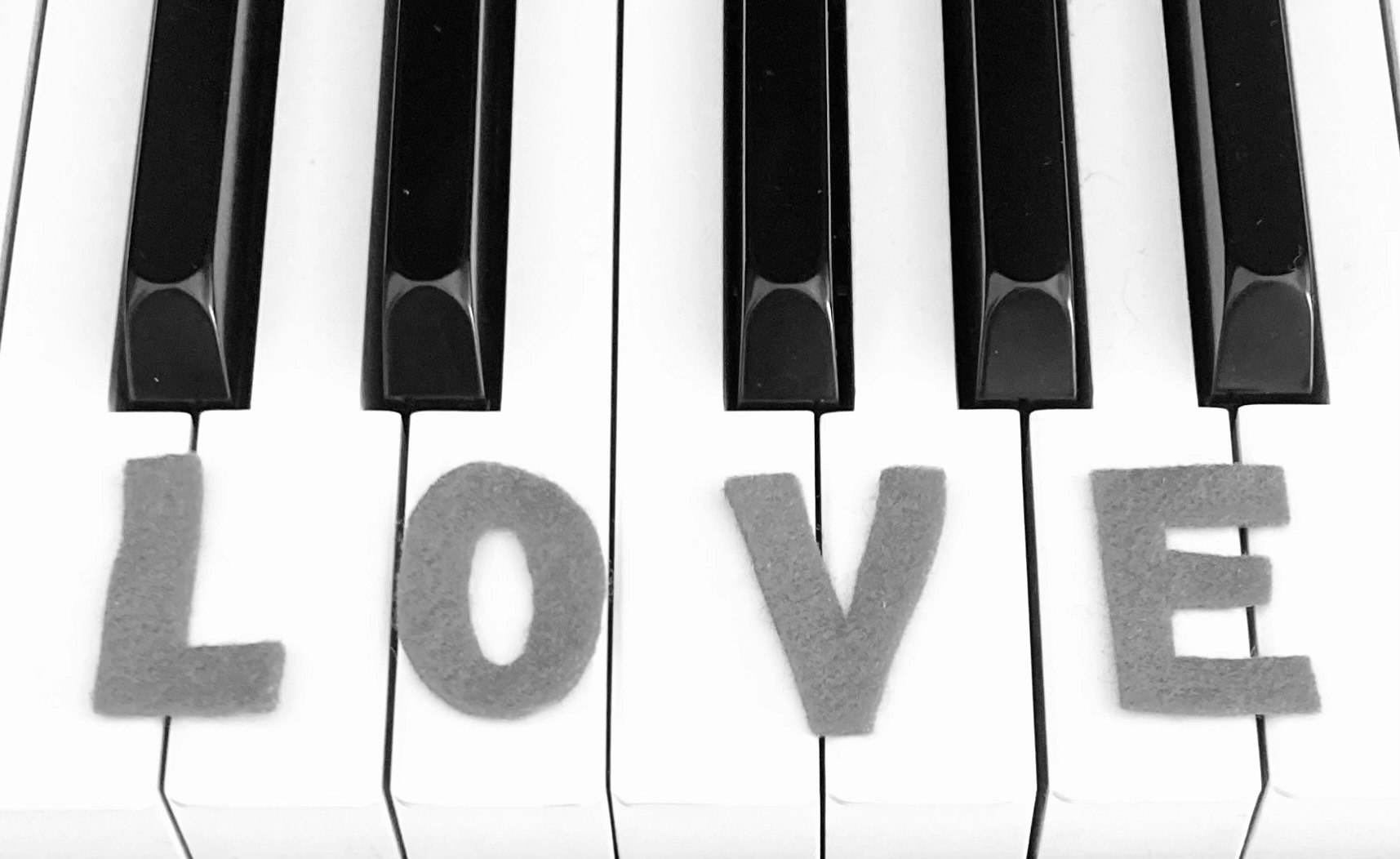 白色钢琴键盘上的“LOVE”字母方块