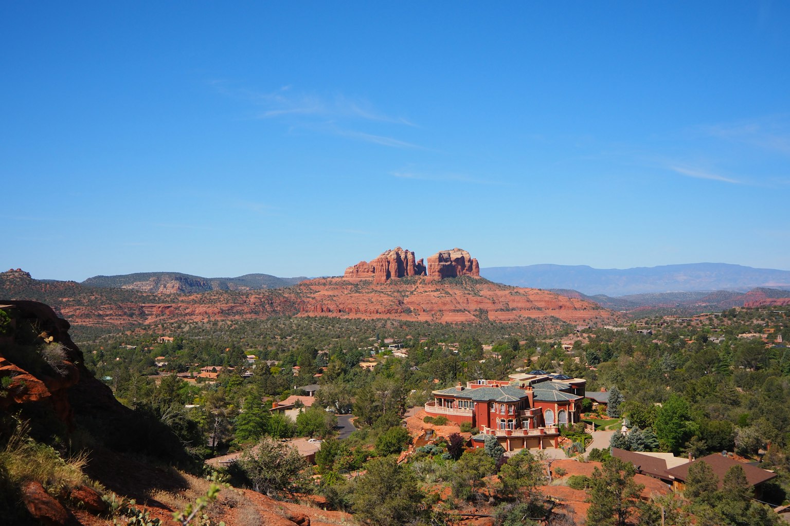 Vista escénica de las formaciones rocosas rojas de Sedona y la vegetación exuberante bajo un cielo azul claro