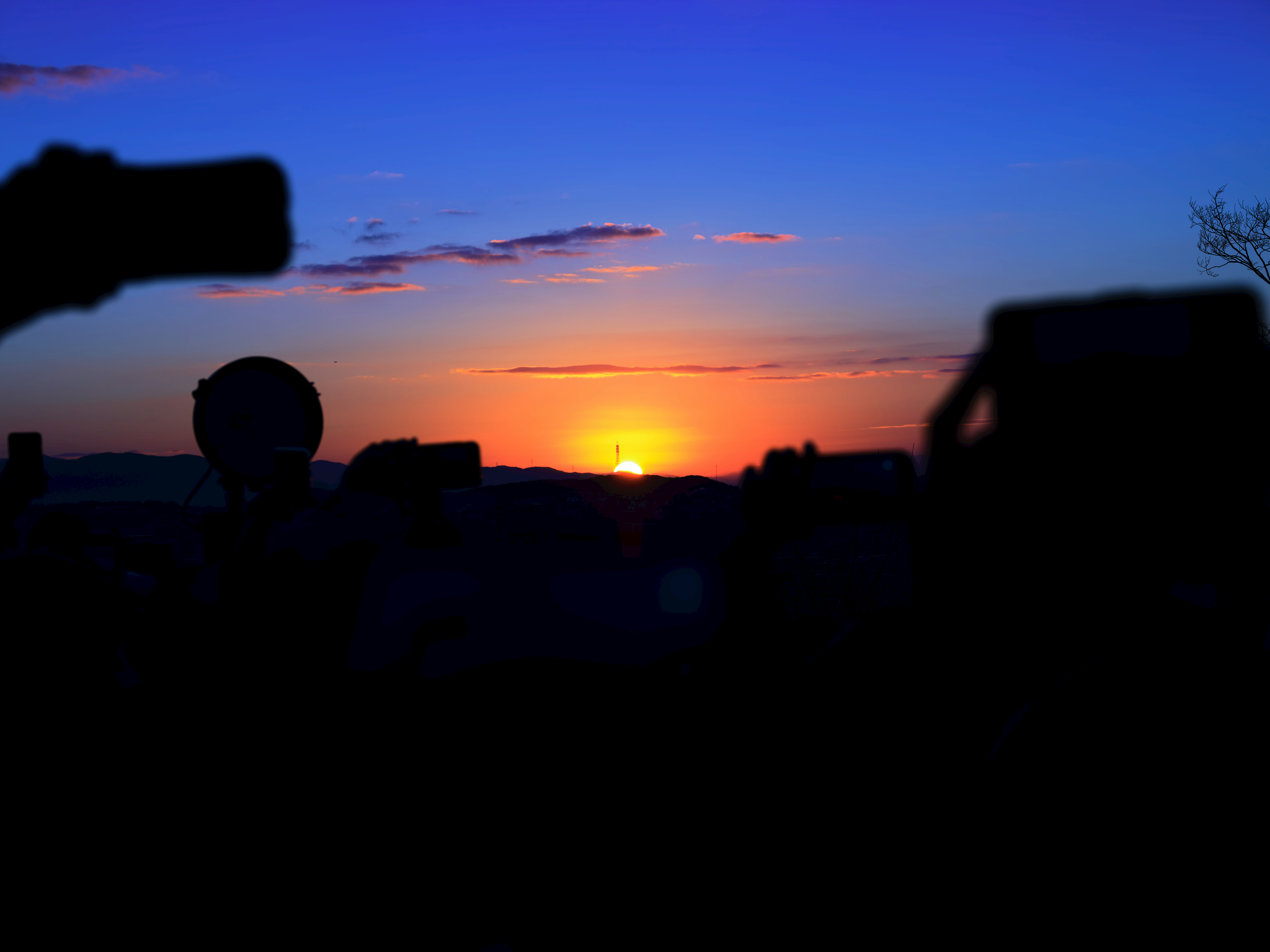 夕陽地平線前的剪影人物與相機