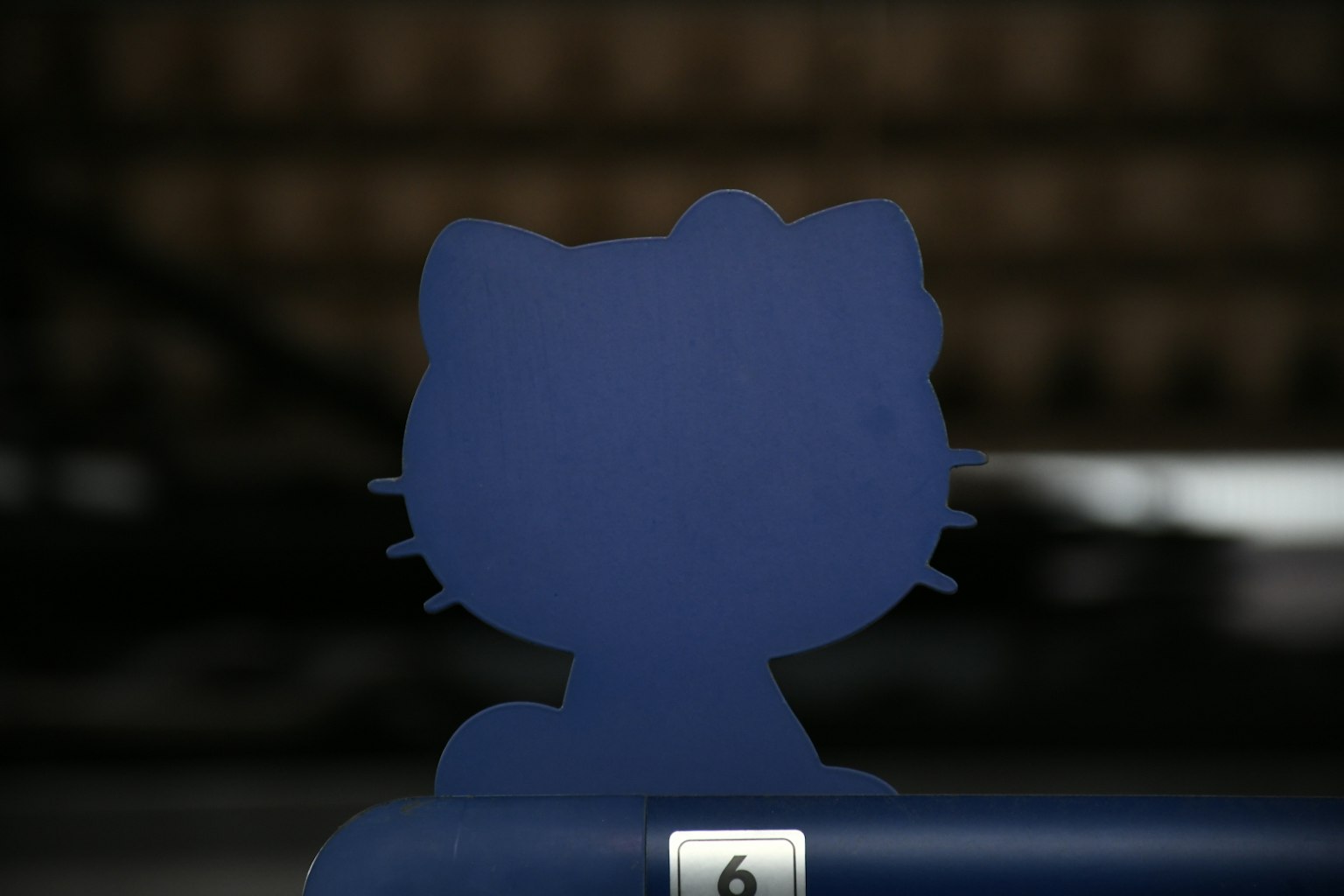 Siluet figur Hello Kitty biru di latar belakang kabur