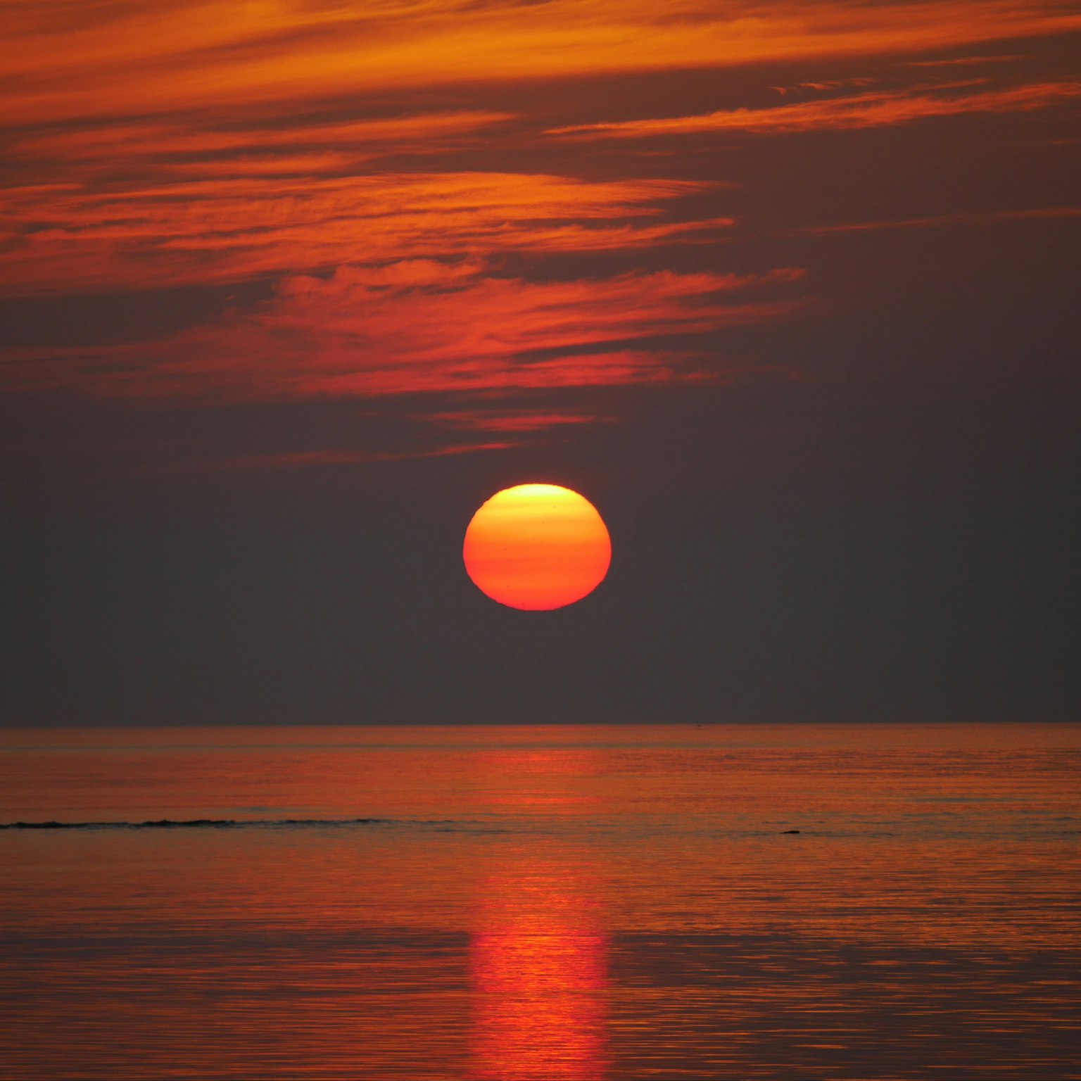 美麗的夕陽在寧靜的海面上，充滿活力的橙色色調