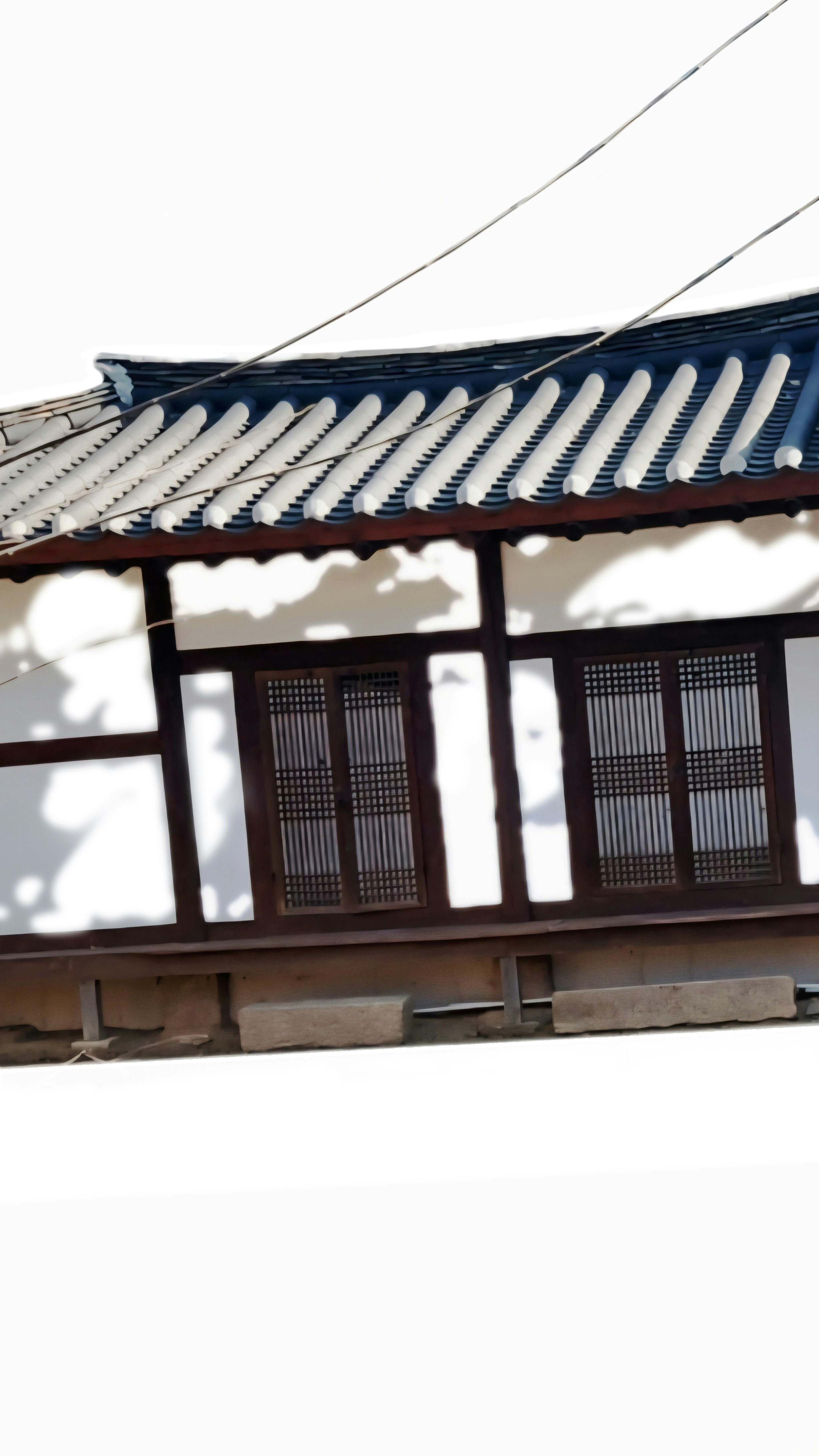 白壁の伝統的な家屋の軒先と格子窓