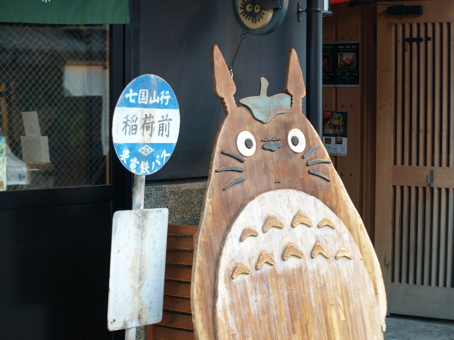 Papan kayu Totoro di pintu masuk toko