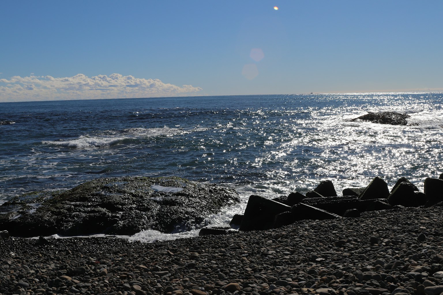 Scenic view of blue ocean waves and rocky beach