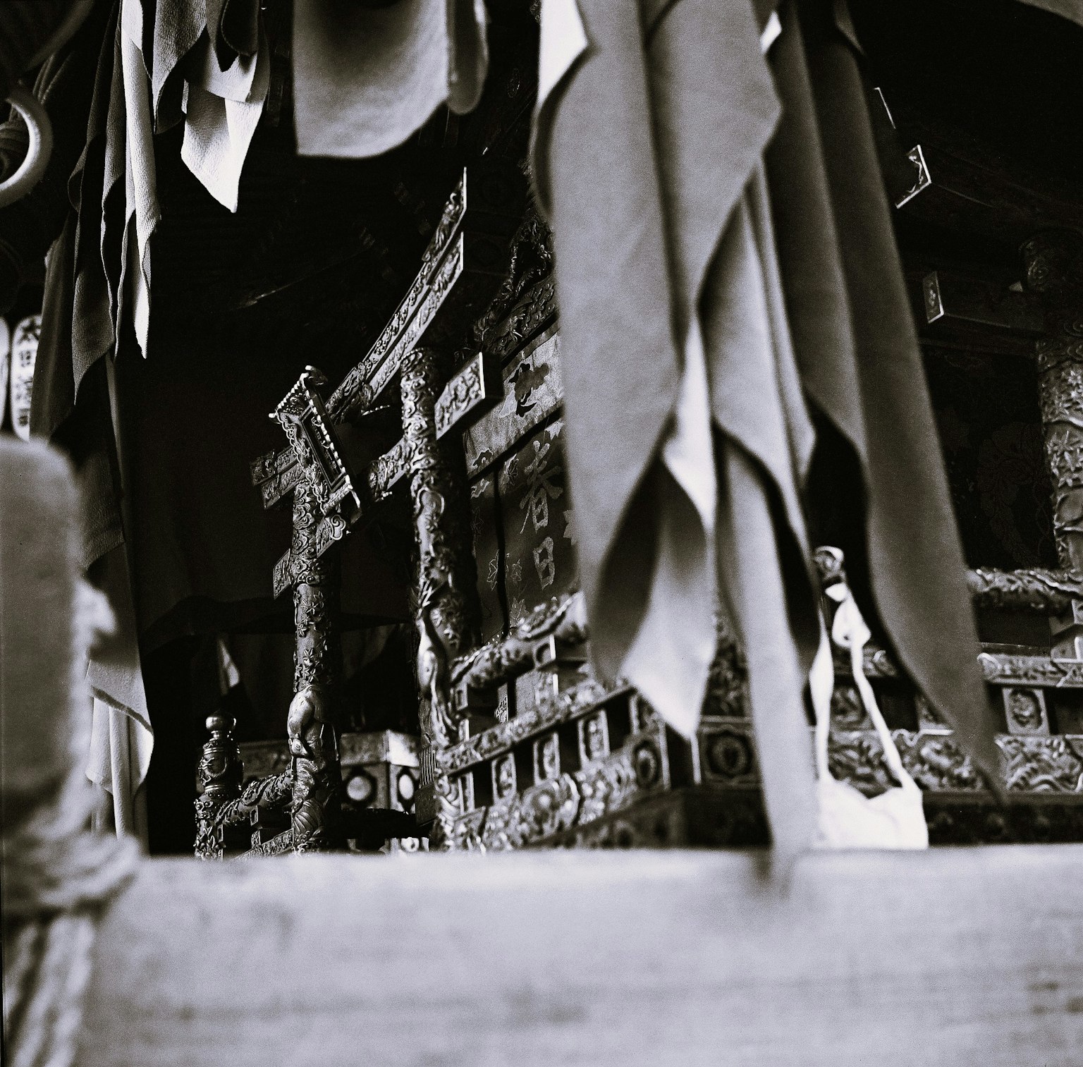 Ảnh đen trắng cho thấy bên trong một ngôi đền với vải treo